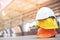 Orange yellow and white hard safety wear helmet hat in the project at construction site building on concrete floor on city with su