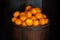 Oranges in a barrel dark background