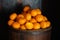 Oranges in a barrel dark background