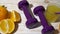 Oranges, juice, dumbbells and banana on wooden background.