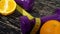 Oranges, juice, dumbbells and measuring tape on wooden background.