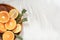 Oranges lemons rosemary, citrus fruits on a wooden plate shadow of a palm leaf. Summer citrus background.