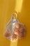 Oranges lie in string bag on bright yellow background and hard sunshine. The concept of zero waste. Using reusable bags