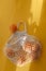 Oranges lie in string bag on bright yellow background and hard sunshine. The concept of zero waste. Using reusable bags