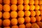 Oranges nicely arranged in market stall for sale.