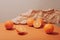 Oranges scattered on a ginger table against a background of crumpled kraft paper