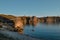 Oranges stones rocks in the light of the setting sun, by the bay with the shore, coast on blue lake Baika