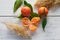 Oranges on white table with green leafs