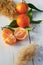 Oranges on white table with green leafs