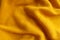 Orangey yellow knitted fabric in soft folds