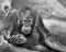 Orangutan baby laying on rocky surface