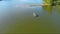 orbit aerial footage of two men in a small boat fishing in the rippling green waters of Lake Acworth