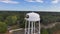 orbit aerial footage of the white water tower on the campus of Grambling State University with the Grambling logo, cars driving