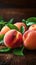 Orchard harvest Ripe peaches with leaves on a wooden backdrop