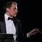 Orchestra conductor in black tuxedo in dark studio