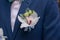 Orchid boutonniere pinned on a groom or male guest jacket