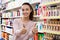 Ordinary female customer posing near shelves