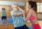 Ordinary female is fighting with trainer on the self-defense course for woman in sport club