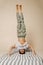 Ordinary indian boy standing on his head on a striped mattress