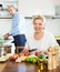 Ordinary mature couple cooking food with vegetables