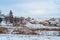 Ordinary Ukrainian village in winter, houses, households, on a hill, everything is covered with snow