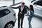 Ordinary working day. Female customer and modern stylish bearded businessman in the automobile saloon