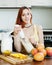 Ordinary young woman making beverages with blender from mango