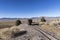 Ore cart sitting on tracks overlooking a desert valley