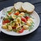 Orecchiette pasta with cherry tomatoes, arugula and Parmesan on a plate light