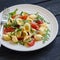 Orecchiette pasta with tomatoes, Parmesan and rocket salad on a plate light