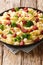Orecchiette recipe with broccoli, spicy sausage, and a simple cream sauce close-up in a plate. vertical