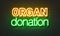 Organ donation neon sign on brick wall background.