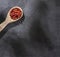 Organic achiote seeds in wooden spoon - Bixa Orellana