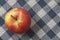 Organic apple on chequered tablecloth