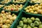 Organic apples in plastic boxes in the supermarket are sorted by varieties. fresh apples store background. Fruits in the pallets