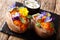 Organic baked sweet potato with edible flowers is served with sauce on the board. horizontal