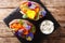 Organic baked sweet potato with edible flowers is served with sauce on the board. horizontal top view