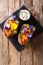 Organic baked sweet potato with edible flowers is served with sauce on the board. Vertical top view