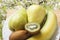 Organic banana, kiwi fruit and pears on wooden table and on colorful flowers background . Top view with copy space. Rustic lifesty