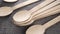 Organic biodegradable bamboo wooden spoon set falling on a textured natural burlap mat