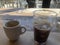 Organic black coffee mixed with ice over a wooden restaurant table.