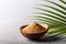 Organic brown palm sugar in coconut bowl on grey concrete background