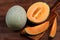 Organic cantaloupe with utensils on wooden table