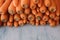 Organic carrots piled together on wooden background. Close up view. Natural carrots at the market ready to eat.