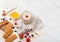 Organic cereal granola bar with berries on marble board with honey spoon and jar of oats and linen towel on marble background.