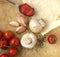 Organic cherry tomatoes, mushrooms, garlic and herbs on an old rustic stone chopping board