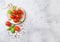 Organic Cherry Tomatoes on the Vine with basil and pepper on chopping board on stone kitchen background. Space for text