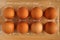 Organic chicken eggs in plastic packaging on brown wooden table