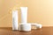 Organic cosmetic white packages with wheat ears composition. Natural skincare products unbranded plastic bottles on beige
