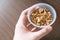 Organic crunchy Granola Cereal with oats and cashew inside a plastic cup with hand holding. Ready to eat product, a nutrition